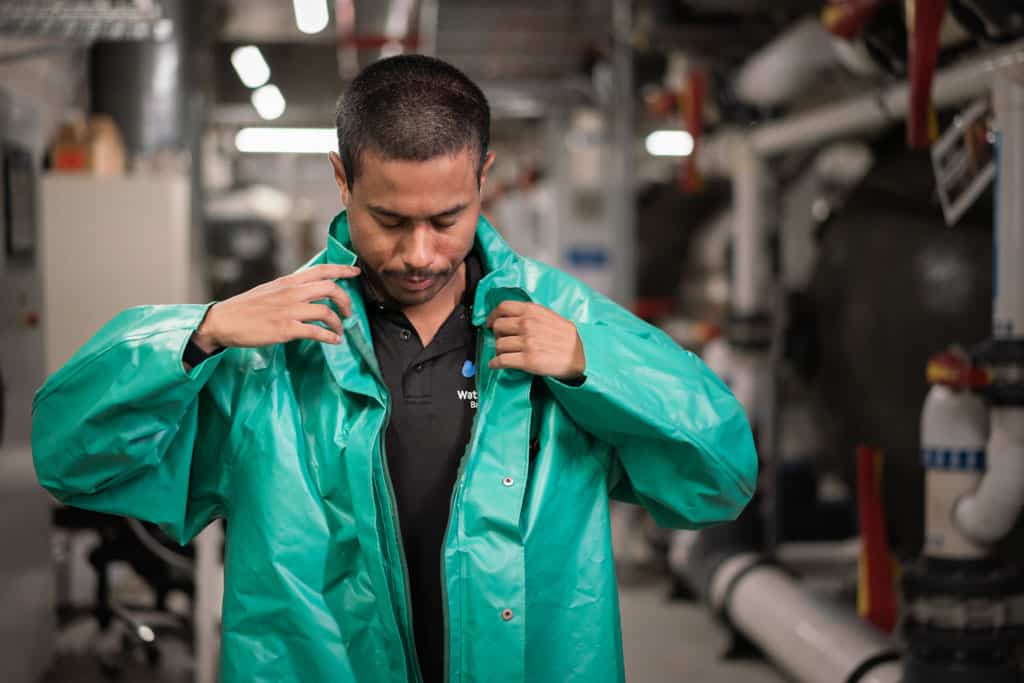 a man wearing a green protective suit before handling chemicals